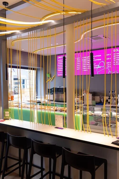 OnePasta Milano Marghera: fotografia degli interni, bancone e illuminazione gialla